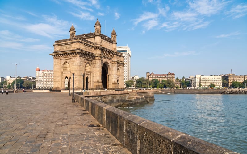 The Gateway of India arch on the Mumbai waterfront, seen from the harbour side in daylight.